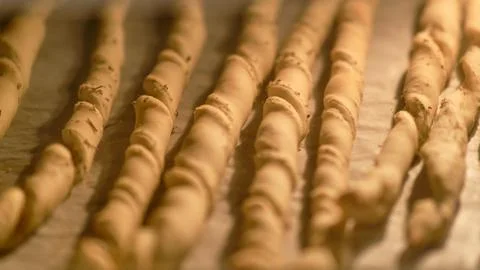 Process of cooking bread strips on disposable baking paper. Grissini breadsti Stock Photos