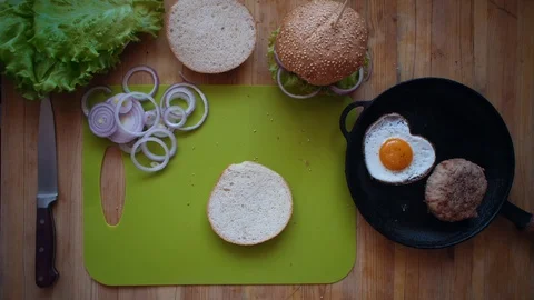 The process of cooking a burger directly above a wooden table. Stock Footage 104723265