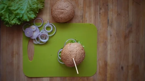 The process of cooking a burger directly above the wooden table . Stock Footage 104723339