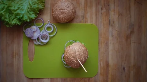 The process of cooking a burger directly above the wooden table . Stock Footage 104723453