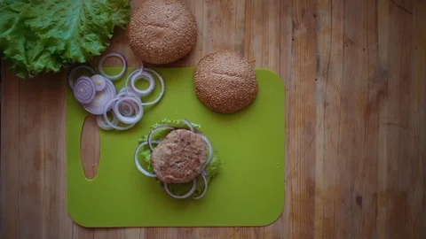 The process of cooking a burger directly above the wooden table . Stock Footage 104723599