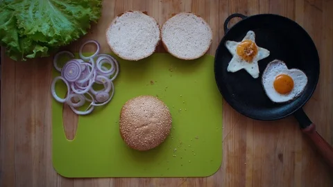 The process of cooking a burger directly above a wooden table. Stock Footage 104724006