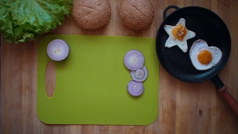 The process of cooking a burger directly above a wooden table. Stock Footage 106376303