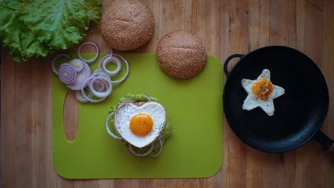 The process of cooking a burger directly above a wooden table. Stock Footage 106822836