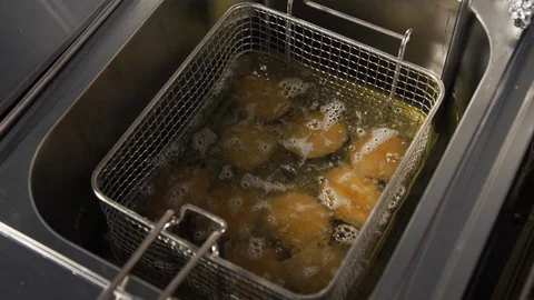 Process of cooking chicken nuggets in the deep fryer Stock Footage 128329713