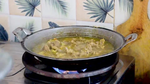 The process of cooking chicken stew using a cauldron Stock Footage 258808428