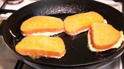 The process of cooking croutons - bread fried in an egg in vegetable oil in a Stock Footage 172161730