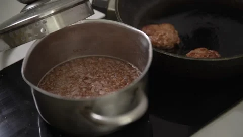 Process of cooking dinner with boiling buckwheat and frying cutlets. Stock Footage 341242044