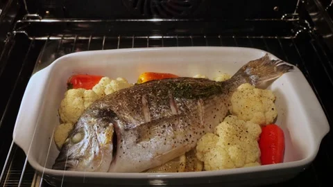 Process of cooking dorado fish with vegetables in the oven. Time lapse. Close up Stock Footage 253597220