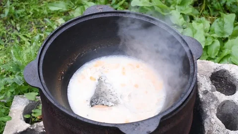 The process of cooking fish soup from salmon head in a cauldron on a bonfire Stock Footage 124691409