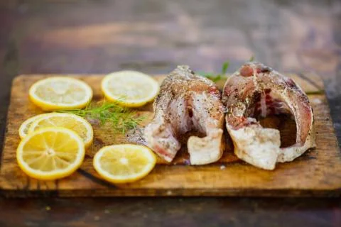 The process of cooking fish, two fresh raw tasty pieces of fish with lemon sl Foto stock