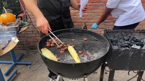 Process of cooking food on grill. Cook roasts chestnuts and corn Stock Footage 252407602