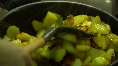 The process of cooking fried potatoes in a gas frying pan in the kitchen Stock Footage 258132107