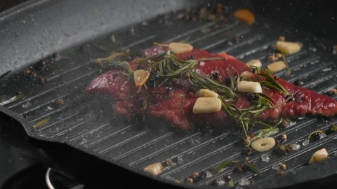Process of cooking juicy medium rare meat steak on grill pan with spices Stock Footage 123572495