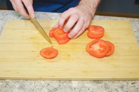 Process of cooking in the kitchen close-up: hands of a cook with a knife and Stock Photos