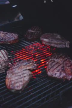 Process of cooking meat on the grill close-up. Stock Photos