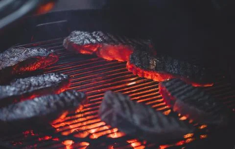 Process of cooking meat on the grill close-up. Stock Photos
