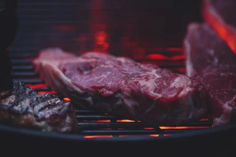 Process of cooking meat on the grill close-up. Stock Photos