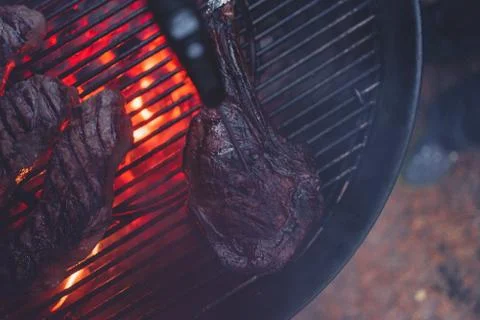 Process of cooking meat on the grill close-up. Stock Photos