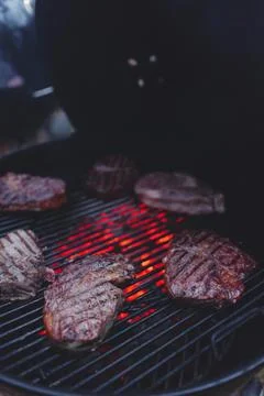 Process of cooking meat on the grill close-up. Stock Photos