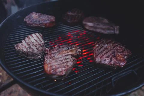 Process of cooking meat on the grill close-up. Stock Photos