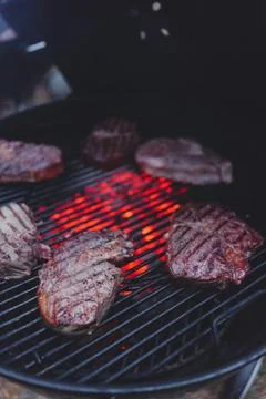 Process of cooking meat on the grill close-up. Stock Photos