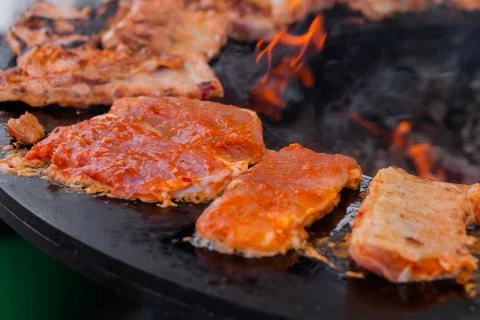 Process of cooking meat steaks on round brazier - close up Stock Photos