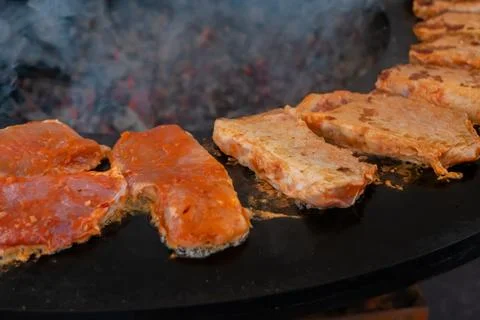 Process of cooking meat steaks on round brazier - close up Stock Photos