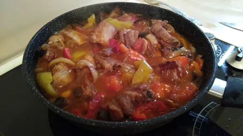 The process of cooking meat with vegetables in a frying pan on the stove close Stock Footage 166165856