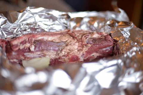 The process of cooking meat with vegetables wrapped in foil, on the grill at  Stock Photos