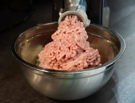 The process of cooking minced using an grinder. Stock Photos