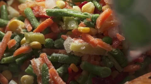 The process of cooking multicolored sliced vegetables in a frying pan Stock Footage 277969130