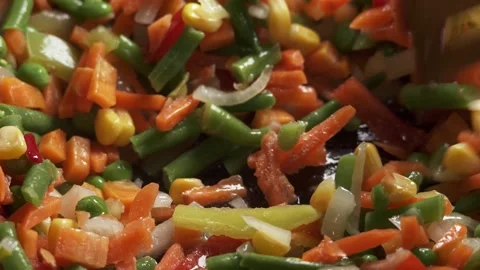 The process of cooking multicolored sliced vegetables in a frying pan Video stock 277969139
