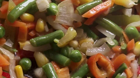 The process of cooking multicolored sliced vegetables in a frying pan Stock Footage 277969152
