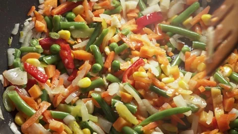 The process of cooking multicolored sliced vegetables in a frying pan Stock Footage 277969182
