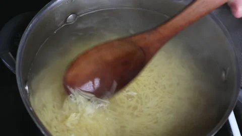 The process of cooking pasta, the cook mixes food with a wooden spoon, close-up Stock Footage 166447883
