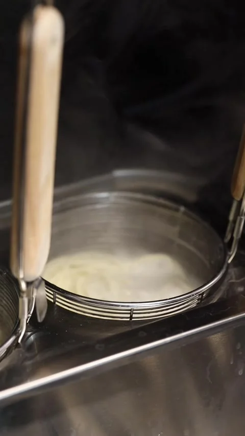 The process of cooking ramen noodles in a professional restaurant kitchen Video stock 332490150