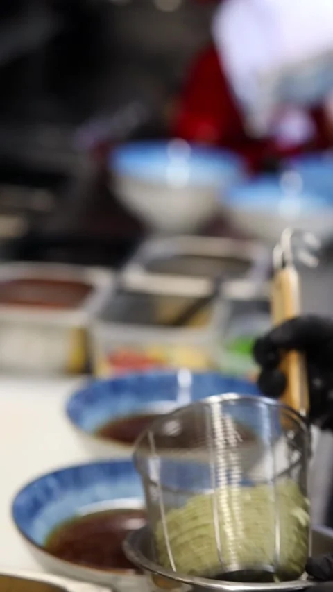 The process of cooking ramen noodles in a professional restaurant kitchen Видео 332490163