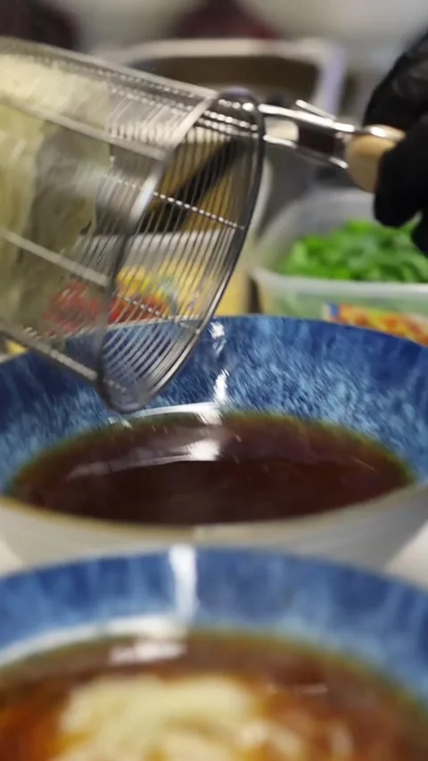 The process of cooking ramen noodles in a professional restaurant kitchen Видео 332490164