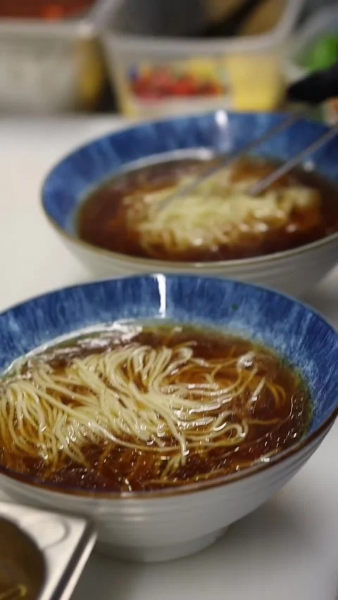 The process of cooking ramen noodles in a professional restaurant kitchen Video stock 332490198