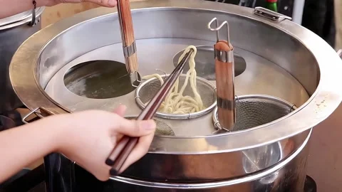The process of cooking rubber noodles in a boiling pan Stock Footage 270347595