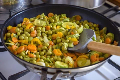Process of cooking saute at home. Stewed vegetables and silicone spatula Stock-Fotos