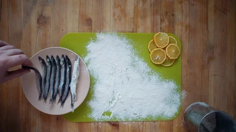 The process of cooking a small fish, preparing for frying in oil in a frying pan Stock Footage 105066564