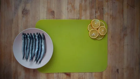 The process of cooking a small fish, preparing for frying in oil in a frying pan Stock Footage 105066688