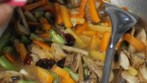 The process of cooking stir-fried vegetables on a pan using a spatula Stock Footage 243636721