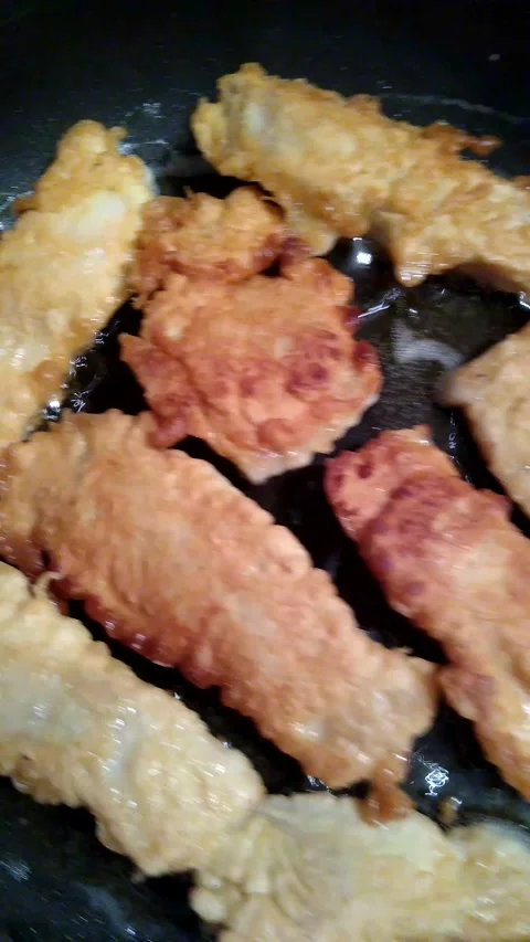 The process of cooking Tilapia fish fillet in batter in a frying pan in Stock Footage 150852992