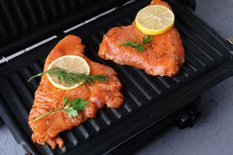 The process of cooking turkey fillets on the electric grill at home, close-up Fotos de archivo