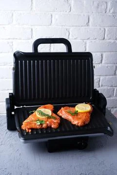 The process of cooking turkey fillets on the electric grill at home, close-up Fotos de archivo