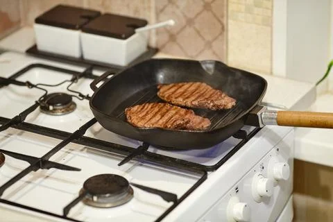 The process of cooking two beef steaks in frying pan, the hands of male che.. Stock Photos