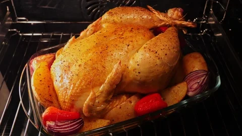 Process of cooking whole chicken with potatoes in the oven Close up. Time lapse Video stock 250130752